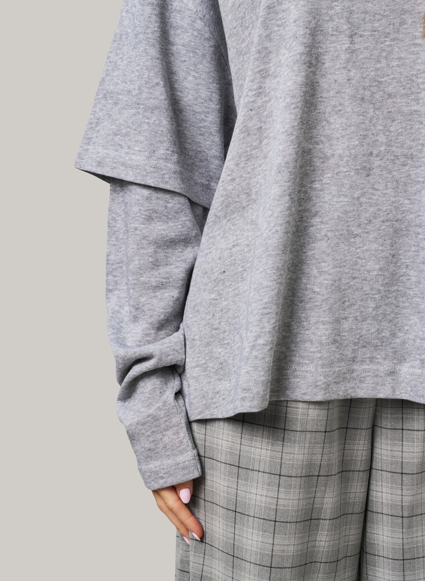 Gray oversized sweater and plaid pants on a neutral background
