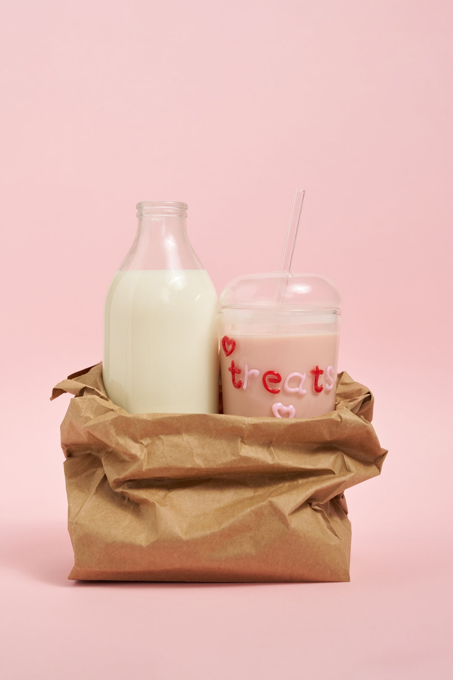Two bottles of milk, one in a glass container and one in a bottle, with 'treat' text on a pink background.