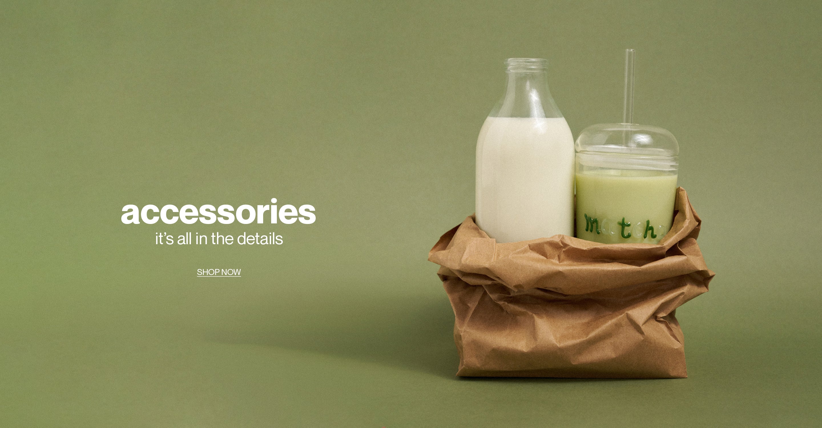 Bottle and cup with straw on a brown paper bag against a green background