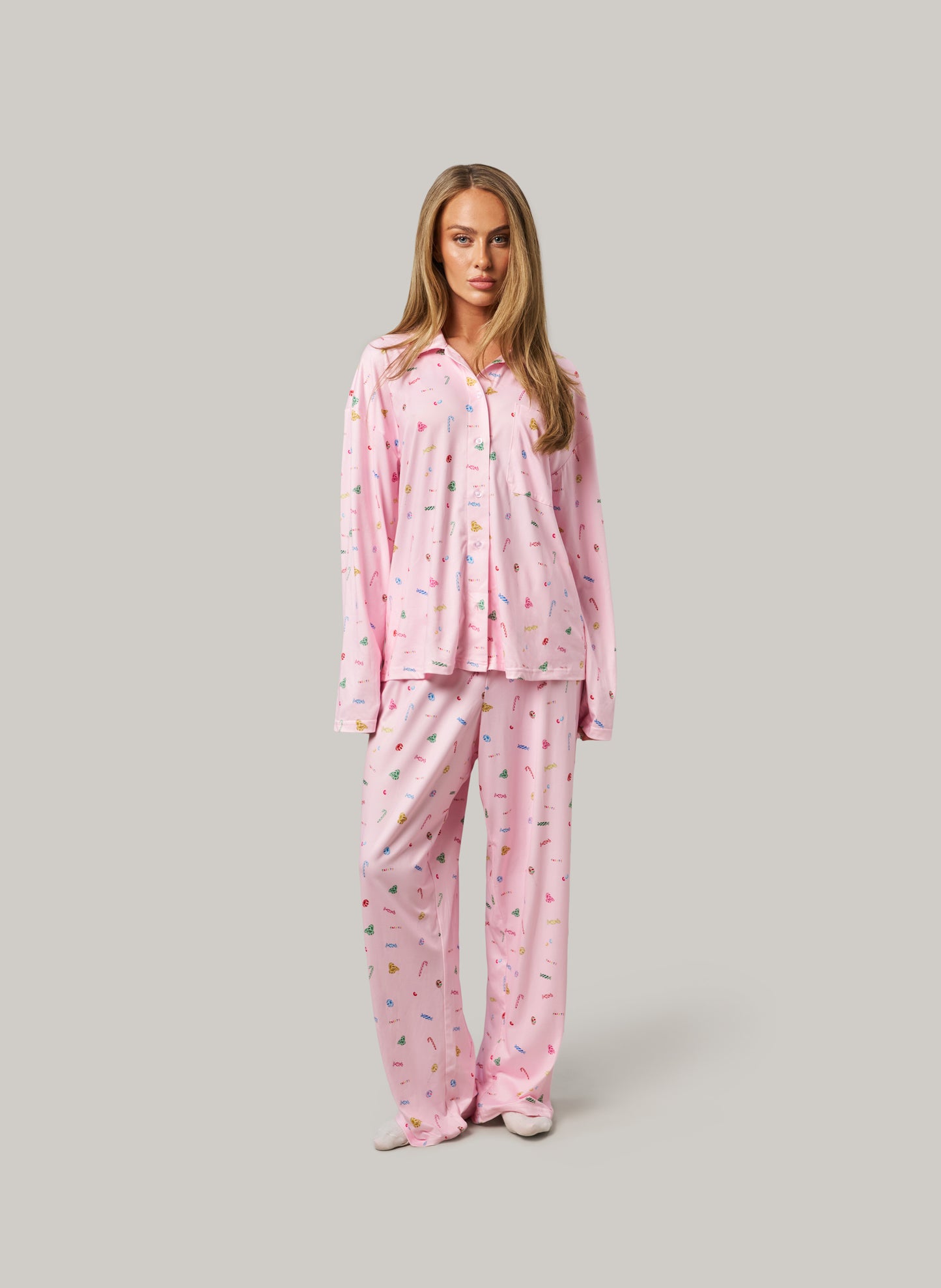 Woman wearing pink pajamas with a pattern on a gray background