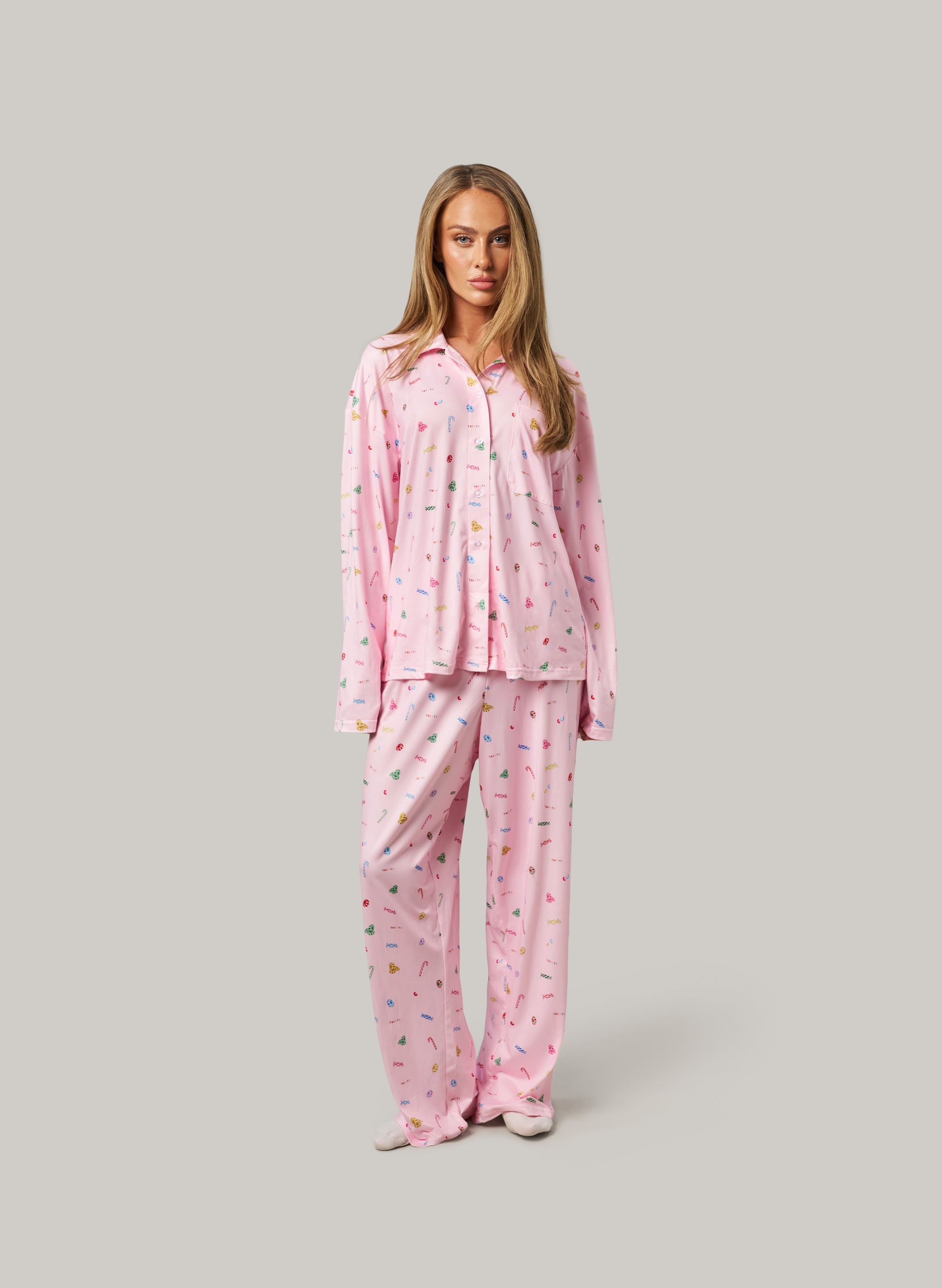 Woman wearing pink pajamas with a pattern on a gray background