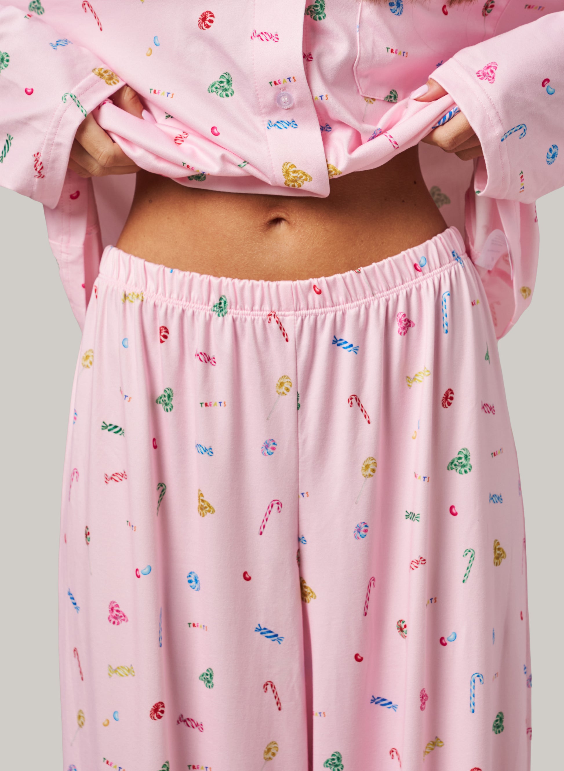 Pink pajama set with colorful candy cane pattern on a plain background