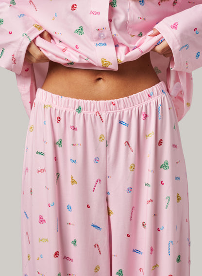 Pink pajama set with colorful candy cane pattern on a plain background