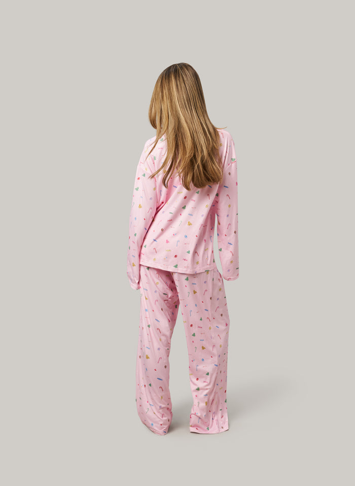 Person wearing pink pajamas with a pattern on a gray background