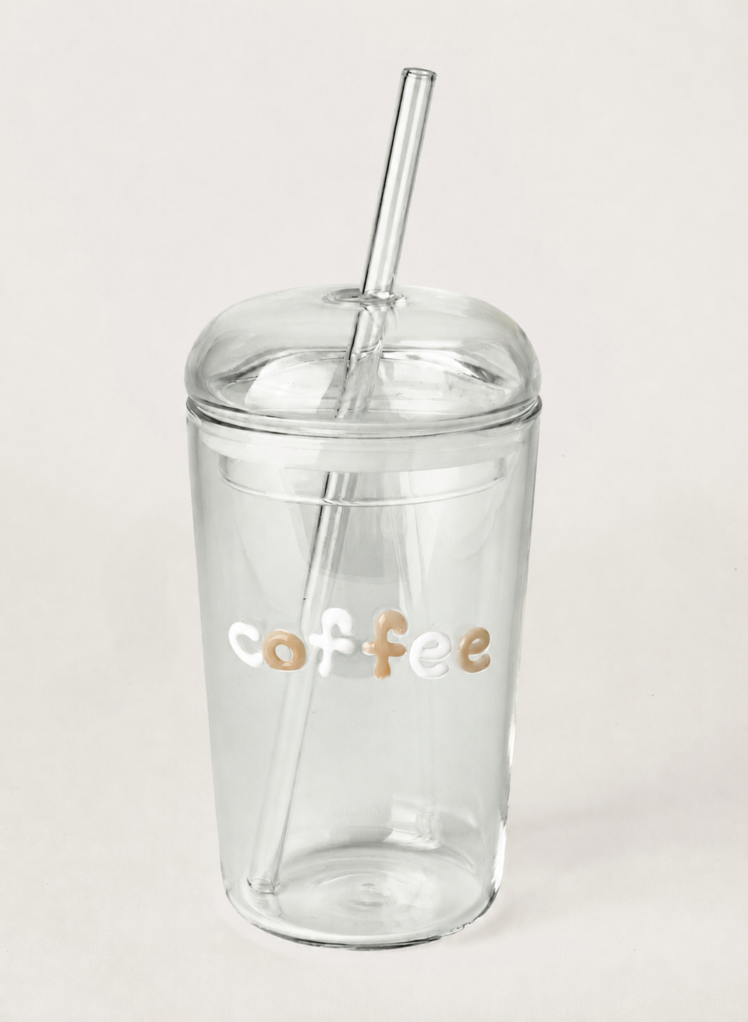 Clear tumbler with 'coffee' text and a straw on a light gray background