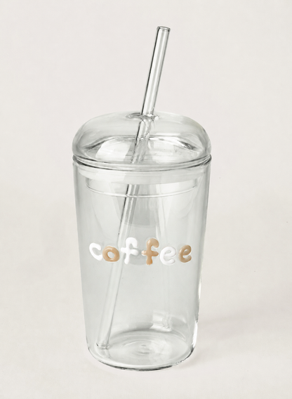 Clear tumbler with 'coffee' text and a straw on a light gray background