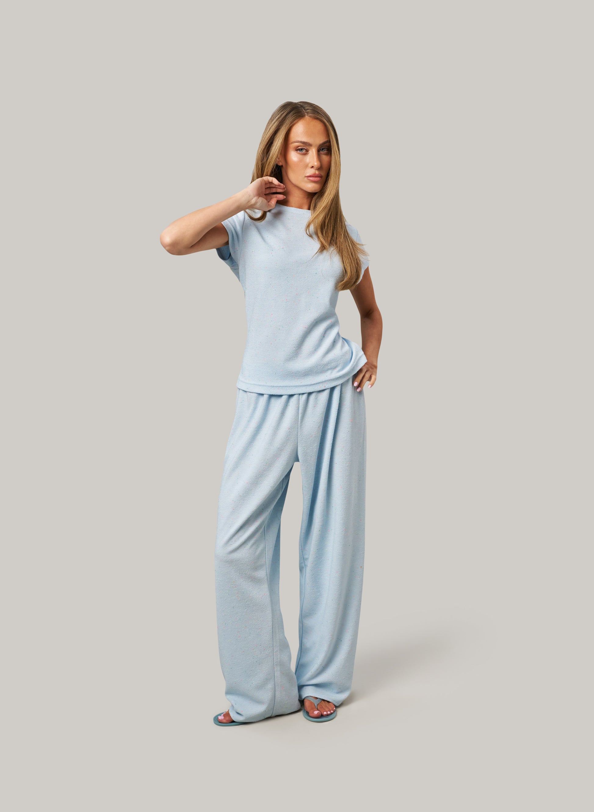 Woman wearing a light blue outfit on a gray background