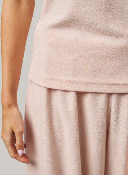 Close-up of a person wearing a light pink textured set against a neutral background