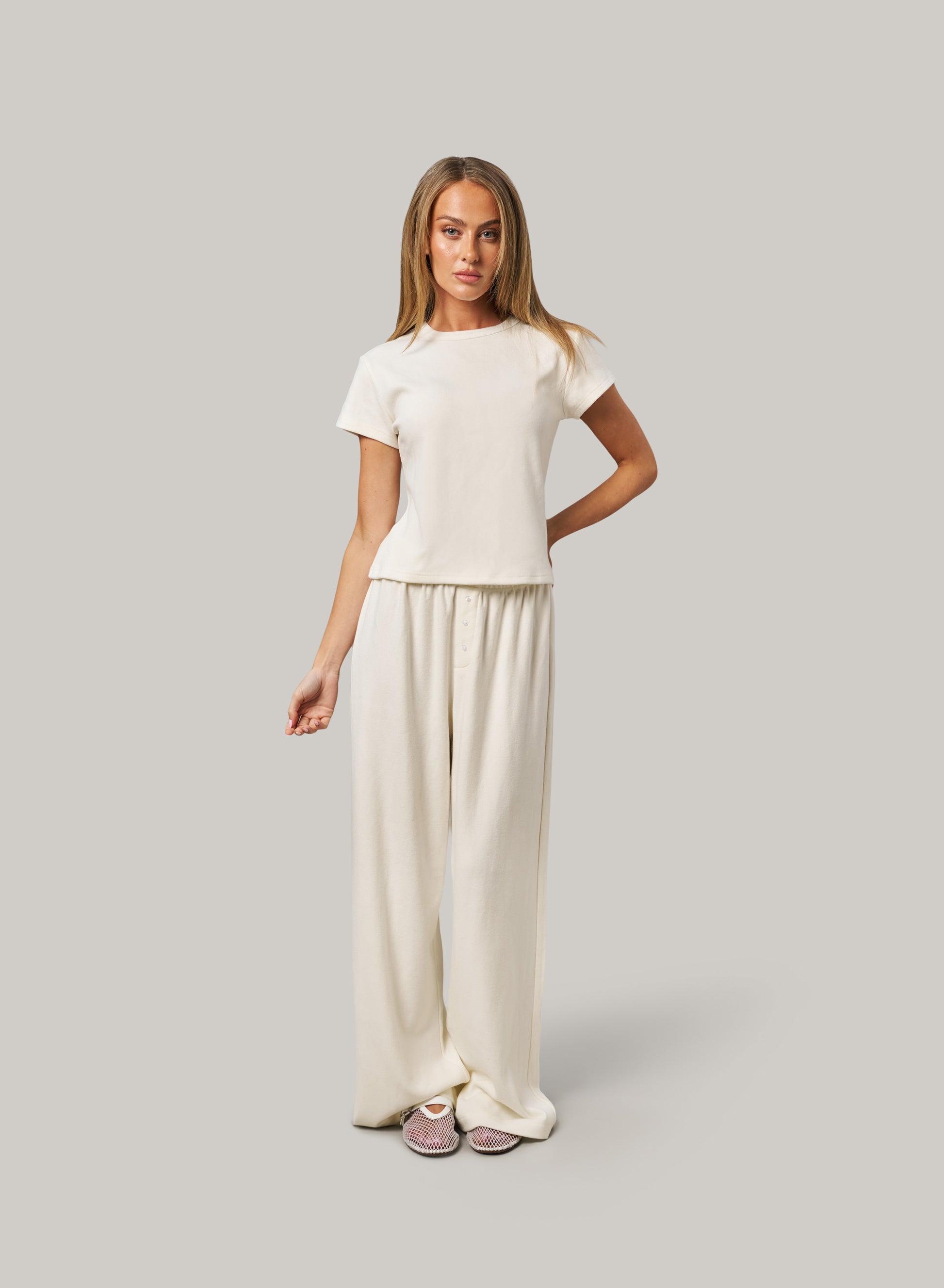 Woman wearing a white outfit on a grey background