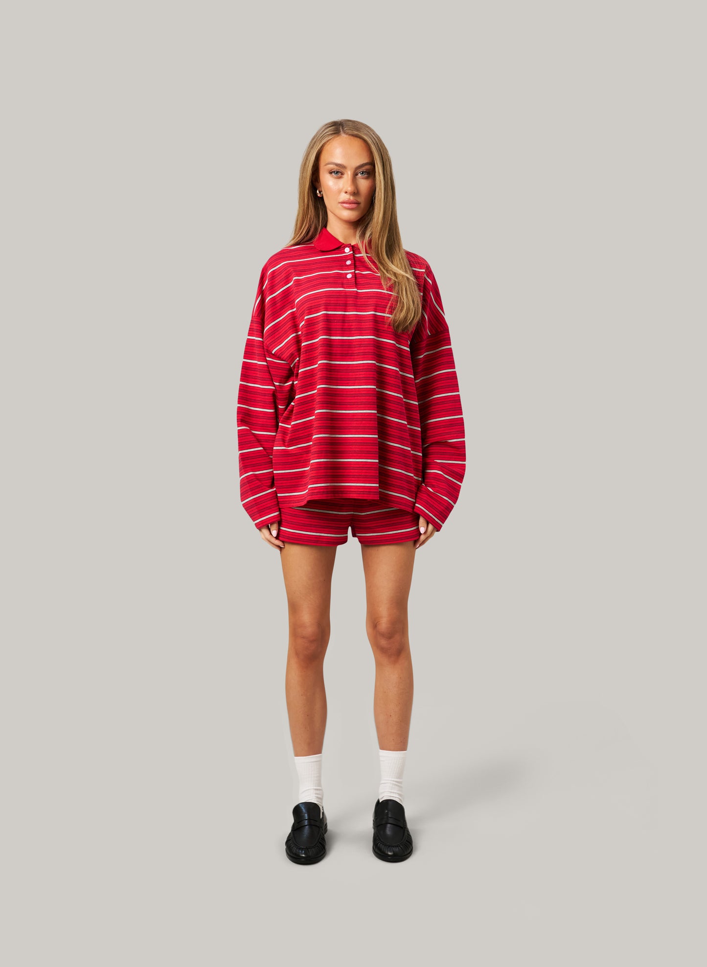 Person wearing a red and white striped outfit on a gray background