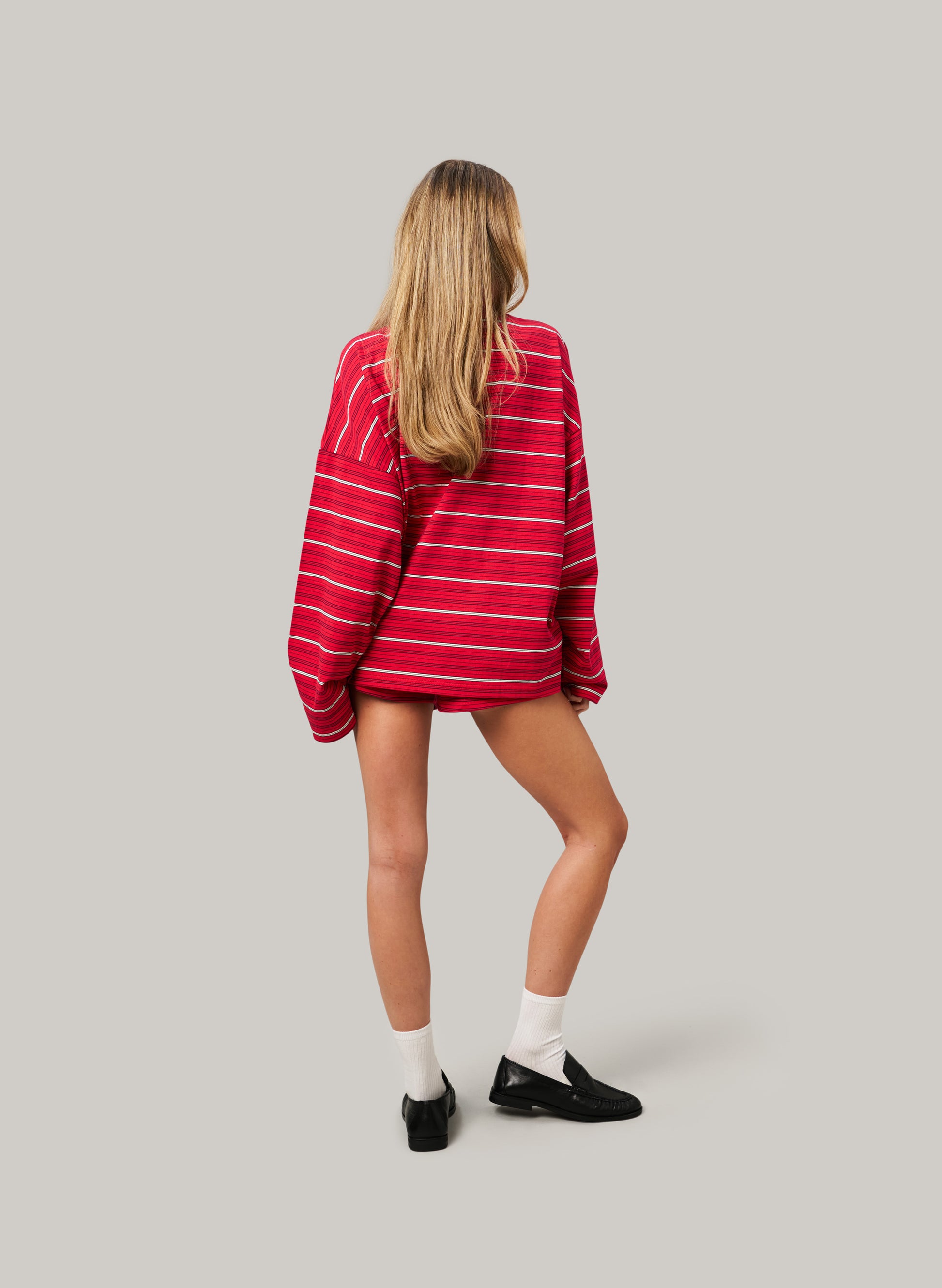 Person wearing a red and white striped sweater on a plain background