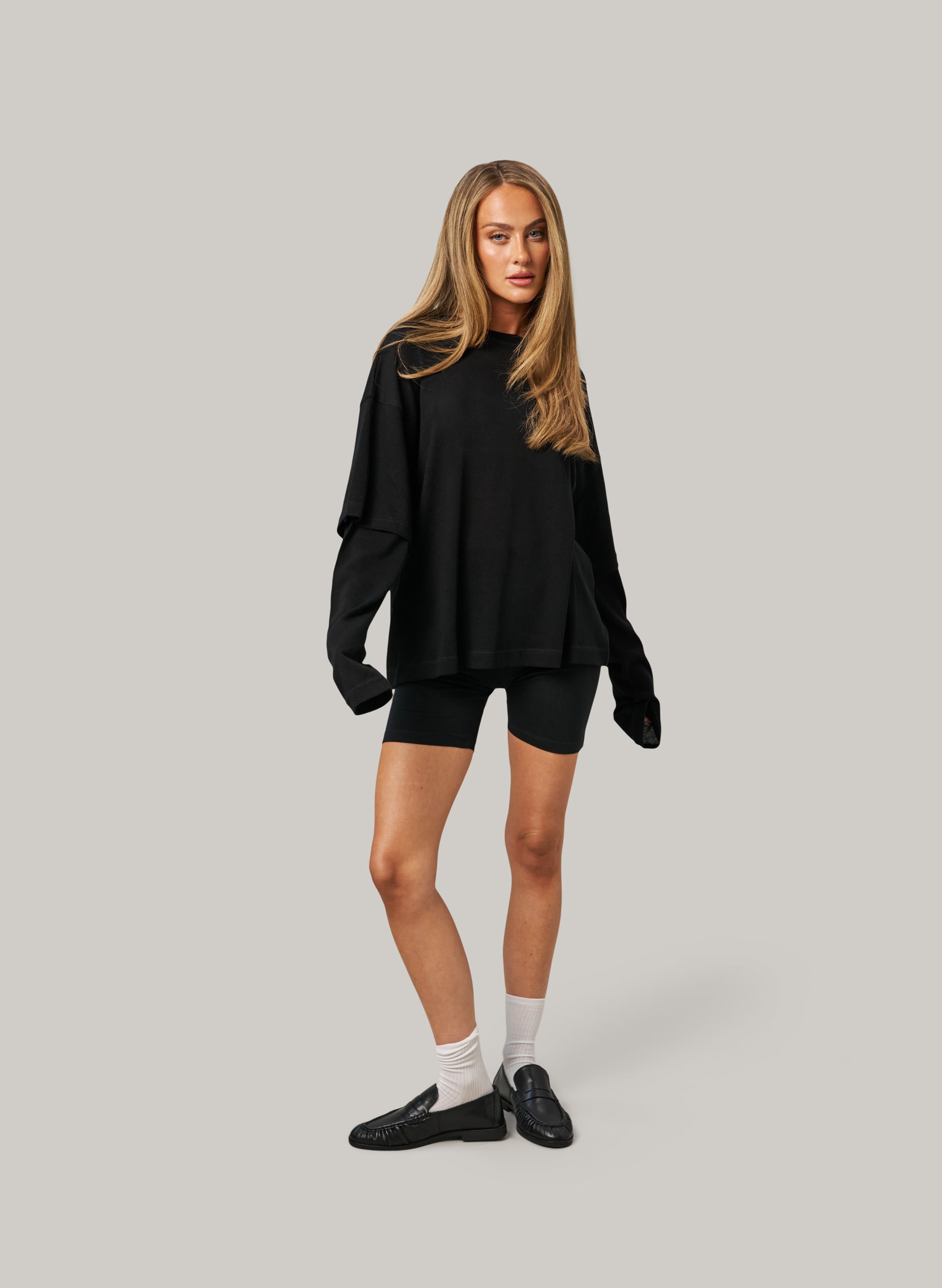 Woman wearing a black outfit on a gray background