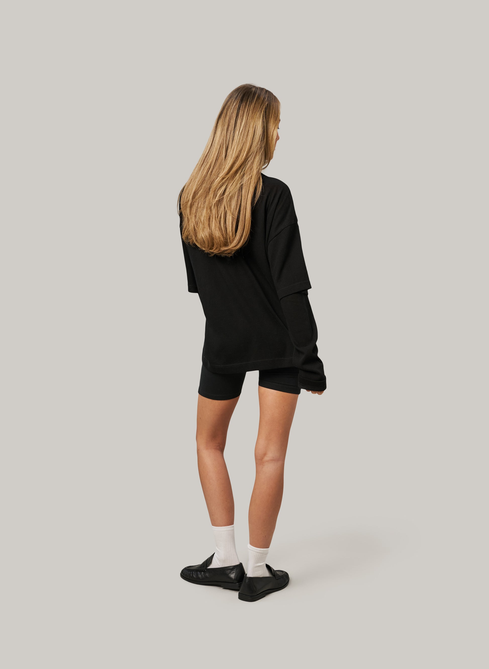 Person wearing a black outfit on a plain background