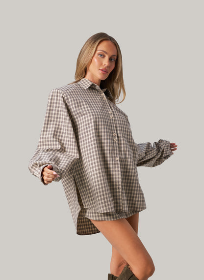 Woman wearing a plaid shirt against a plain background