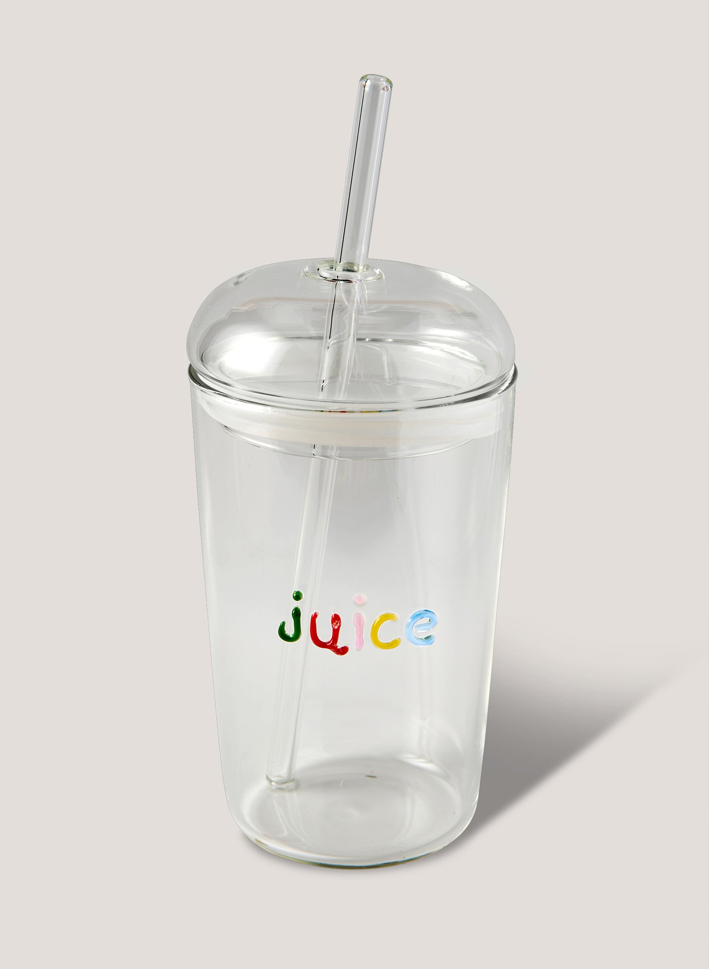 Clear tumbler with colorful 'juice' text and straw on a light background