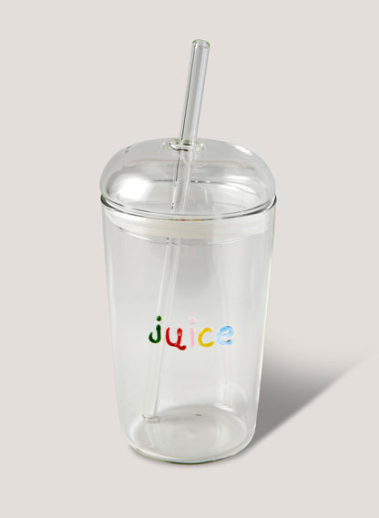 Clear tumbler with colorful 'juice' text and straw on a light background