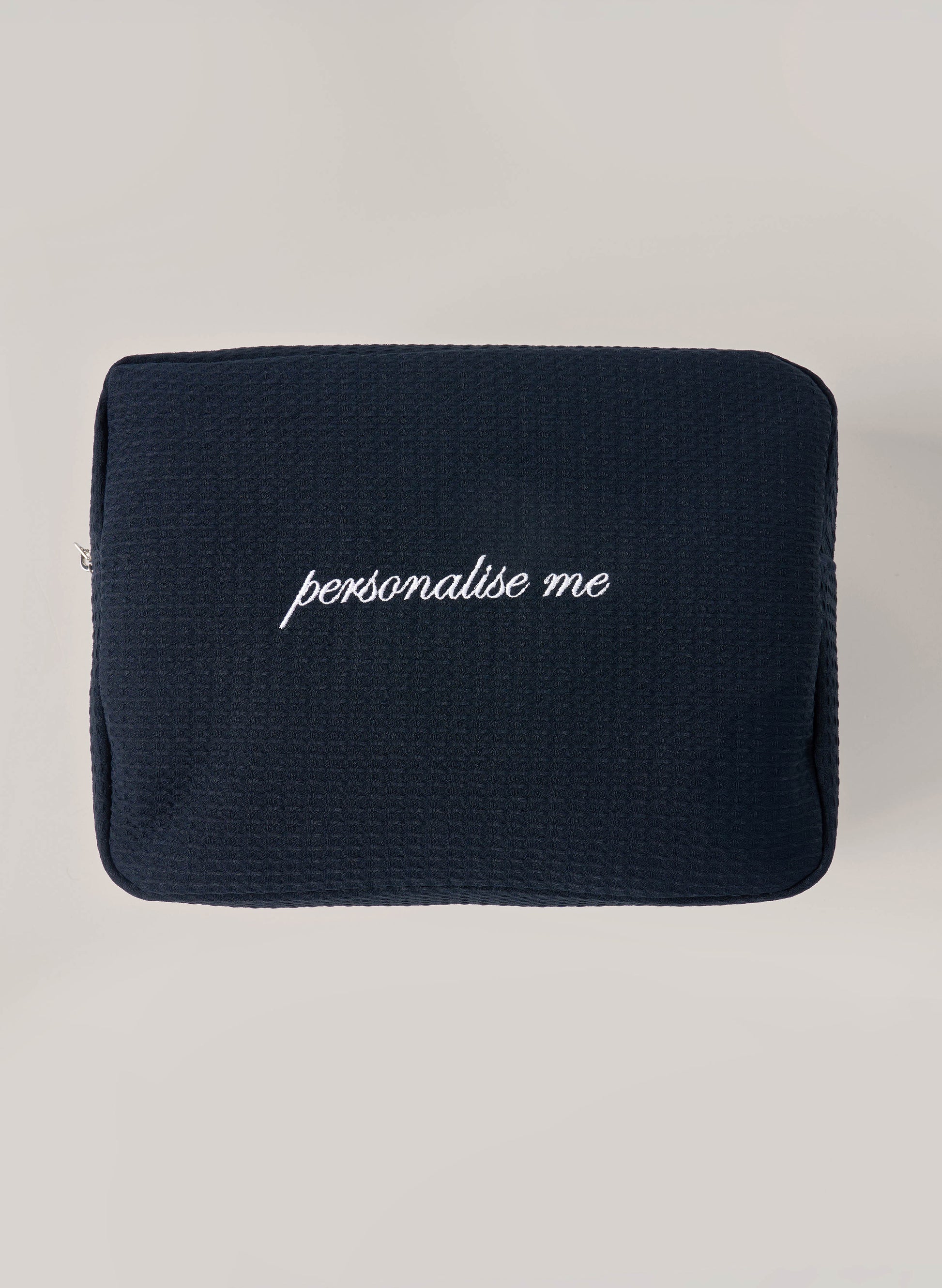 Navy waffle-textured pouch with zipper closure, featuring a red embroidered heart and the words 'personalise me’ on the front