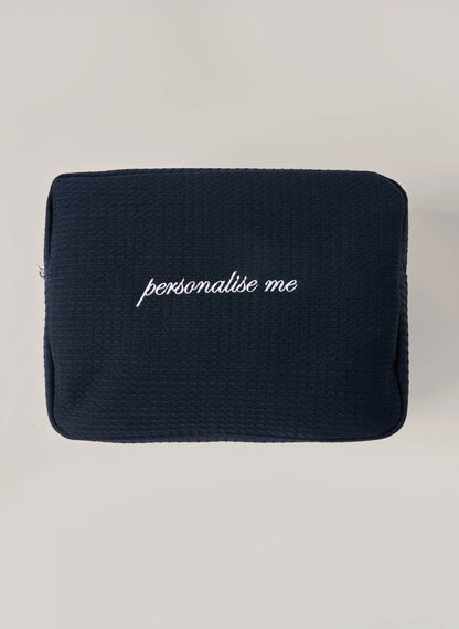 Navy waffle-textured pouch with zipper closure, featuring a red embroidered heart and the words 'personalise me’ on the front