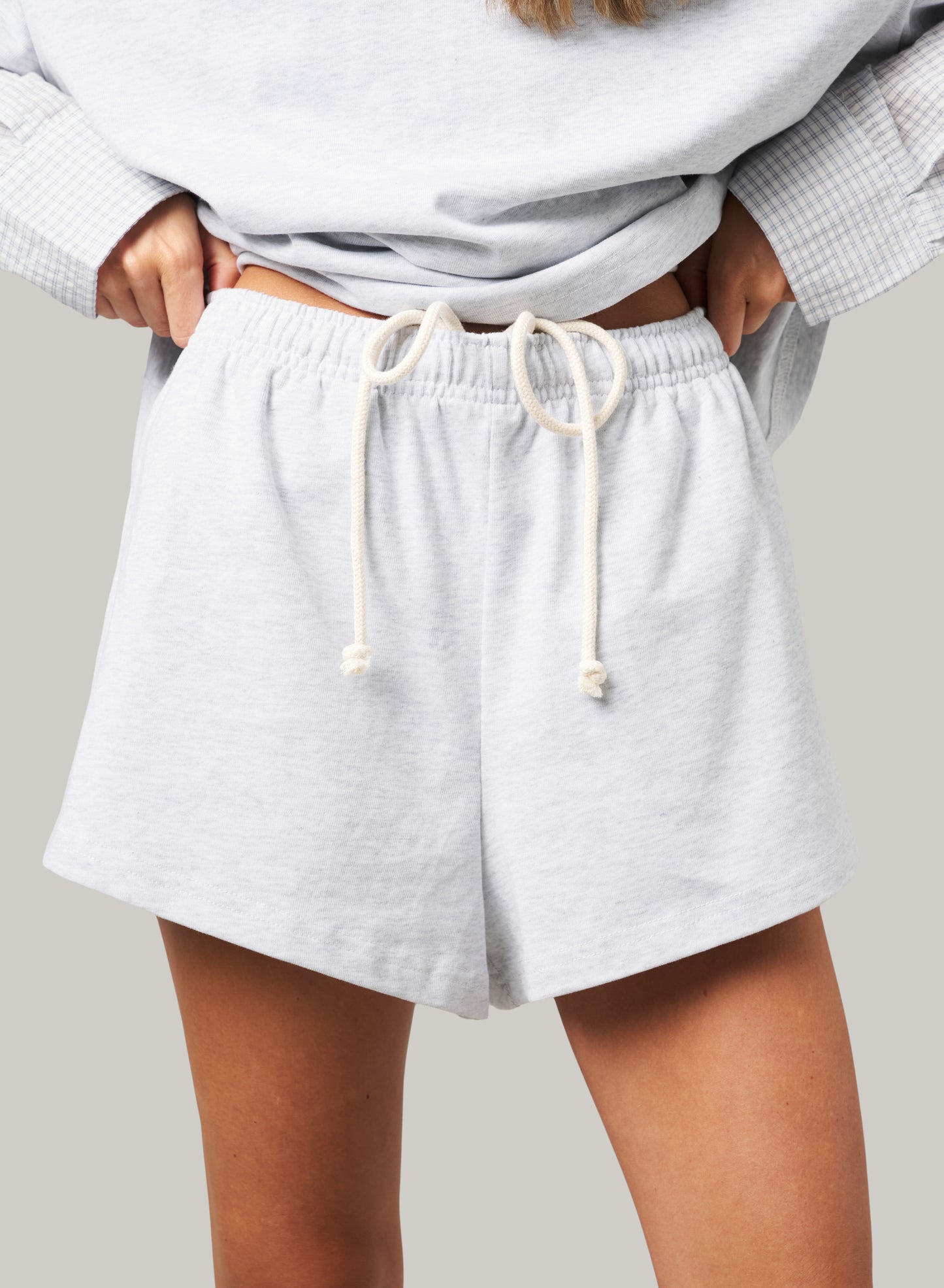 Light gray shorts with a drawstring on a neutral background