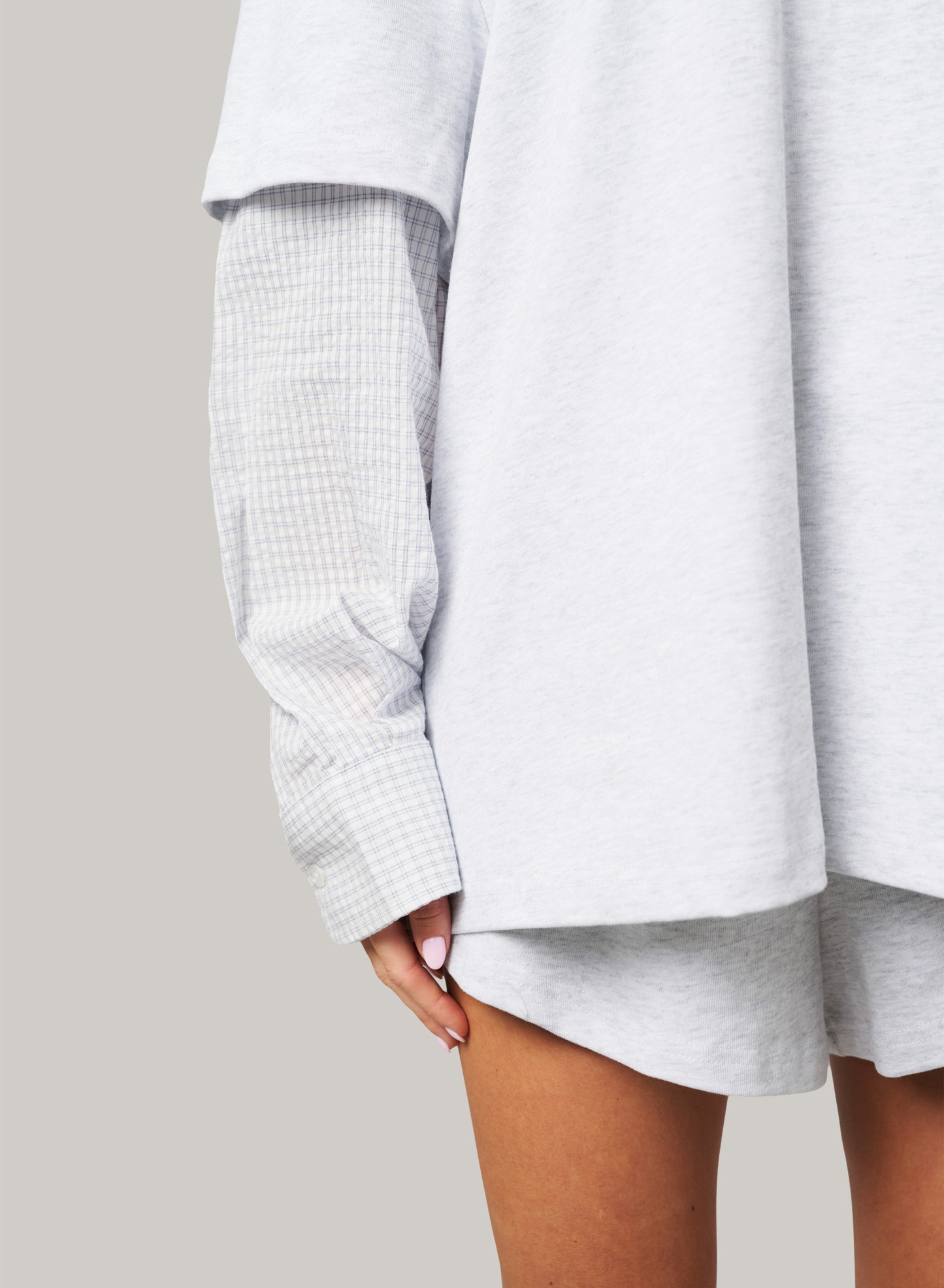 Light gray oversized shirt with rolled-up sleeves on a neutral background