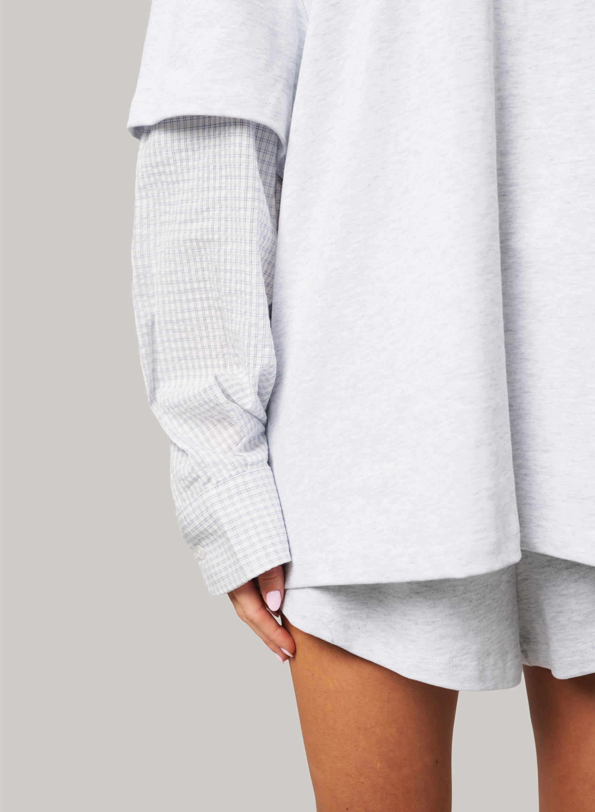 Light gray oversized shirt with rolled-up sleeves on a neutral background