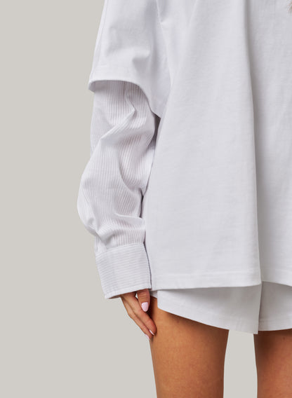 Light gray oversized shirt worn by a person on a plain background