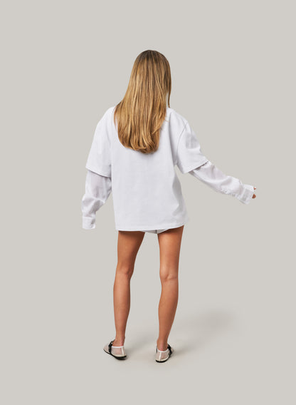 Person wearing a white oversized sweatshirt on a plain background