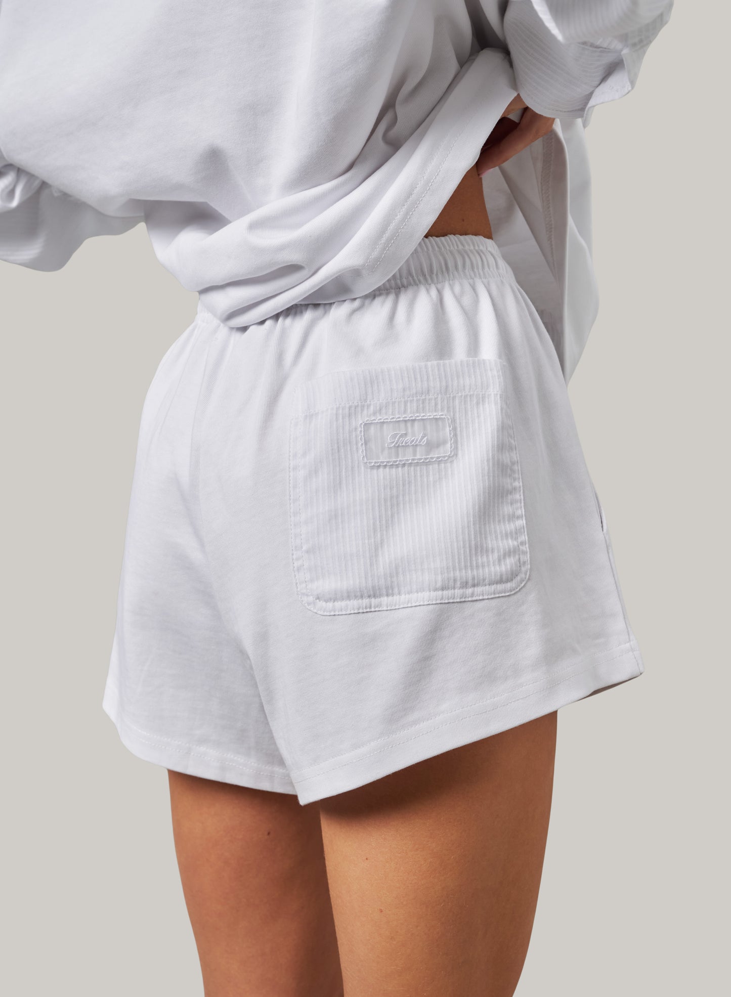 Light gray shorts worn by a person on a neutral background