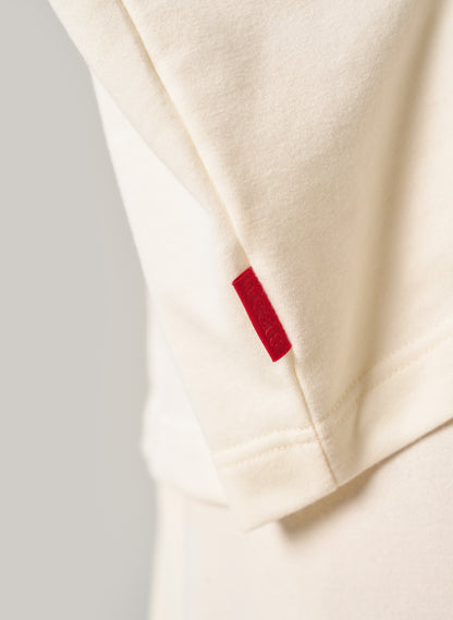 Close-up of a beige fabric with a red label on a light grey background