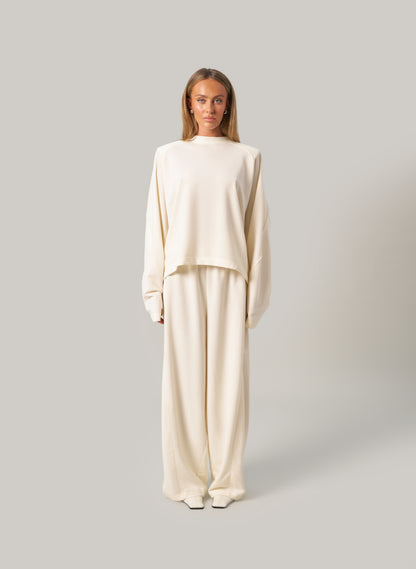 Woman wearing a beige outfit on a plain background