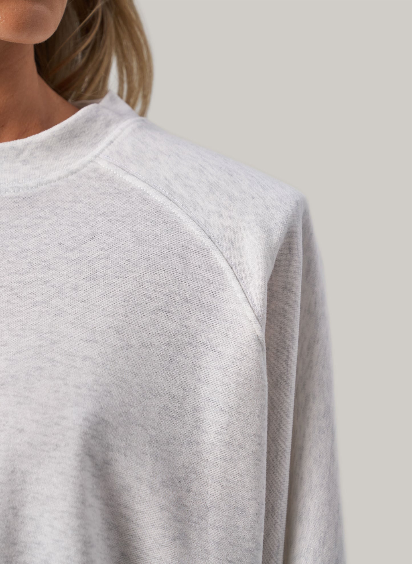Gray sweatshirt worn by a person on a plain background