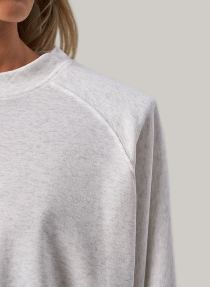 Gray sweatshirt worn by a person on a plain background