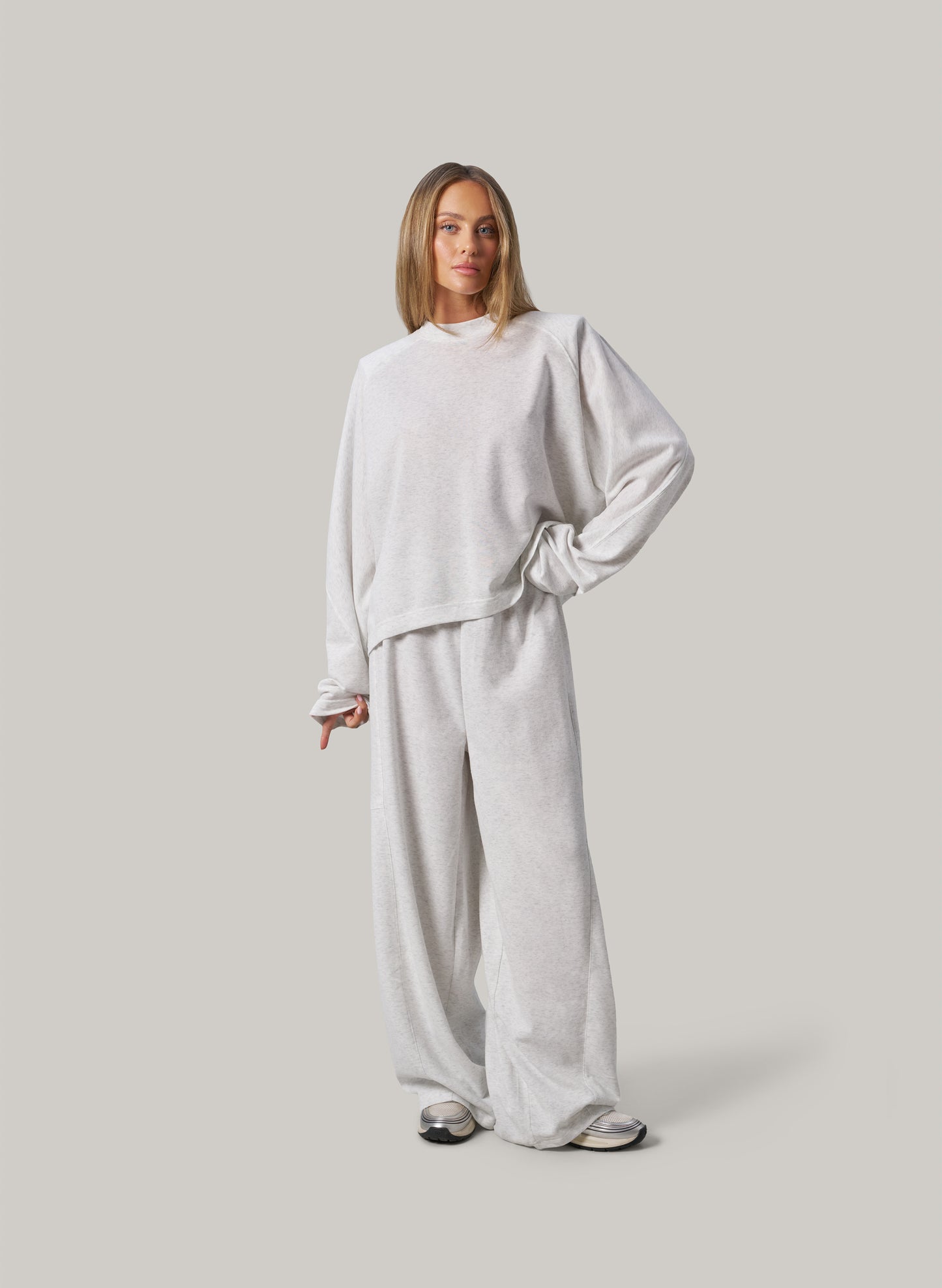 Person wearing a light grey outfit on a plain background