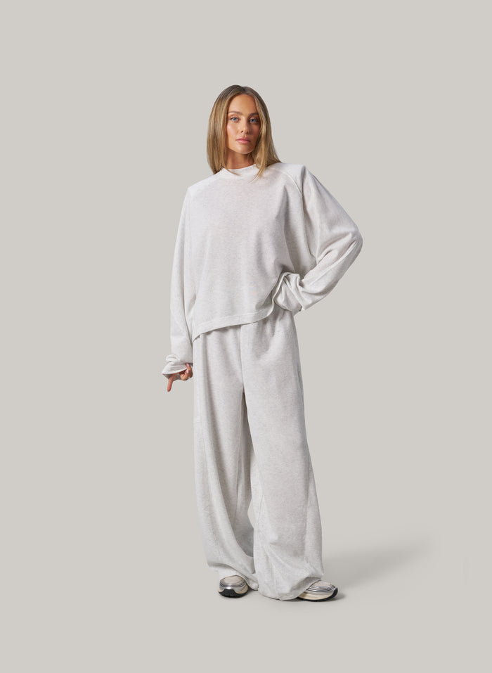 Person wearing a light grey outfit on a plain background