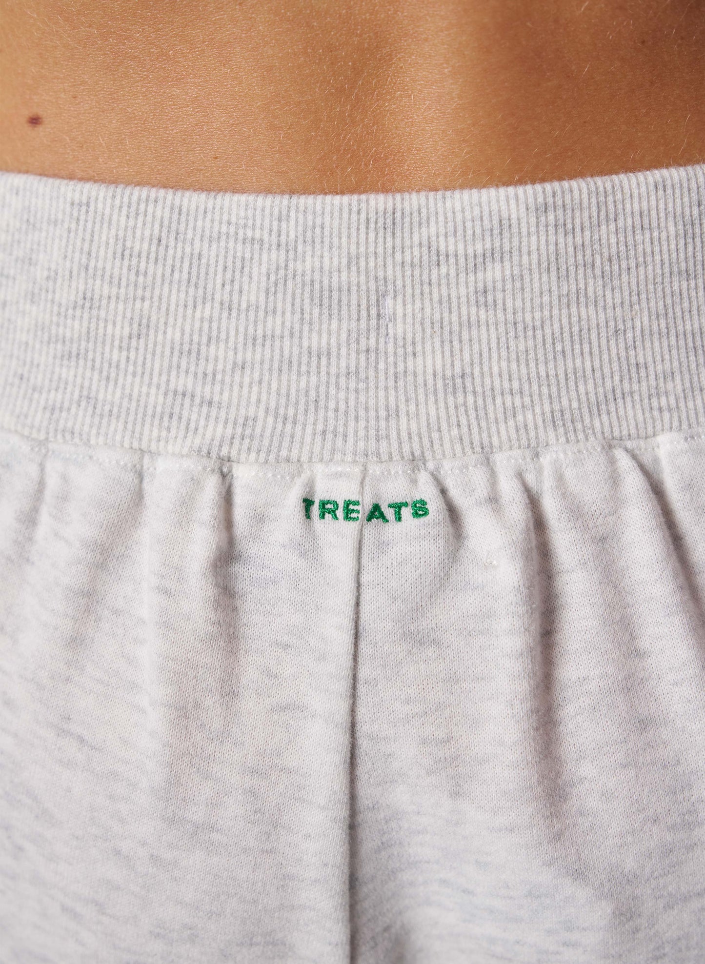 Gray sweatpants with 'TREATS' branding on the waistband.