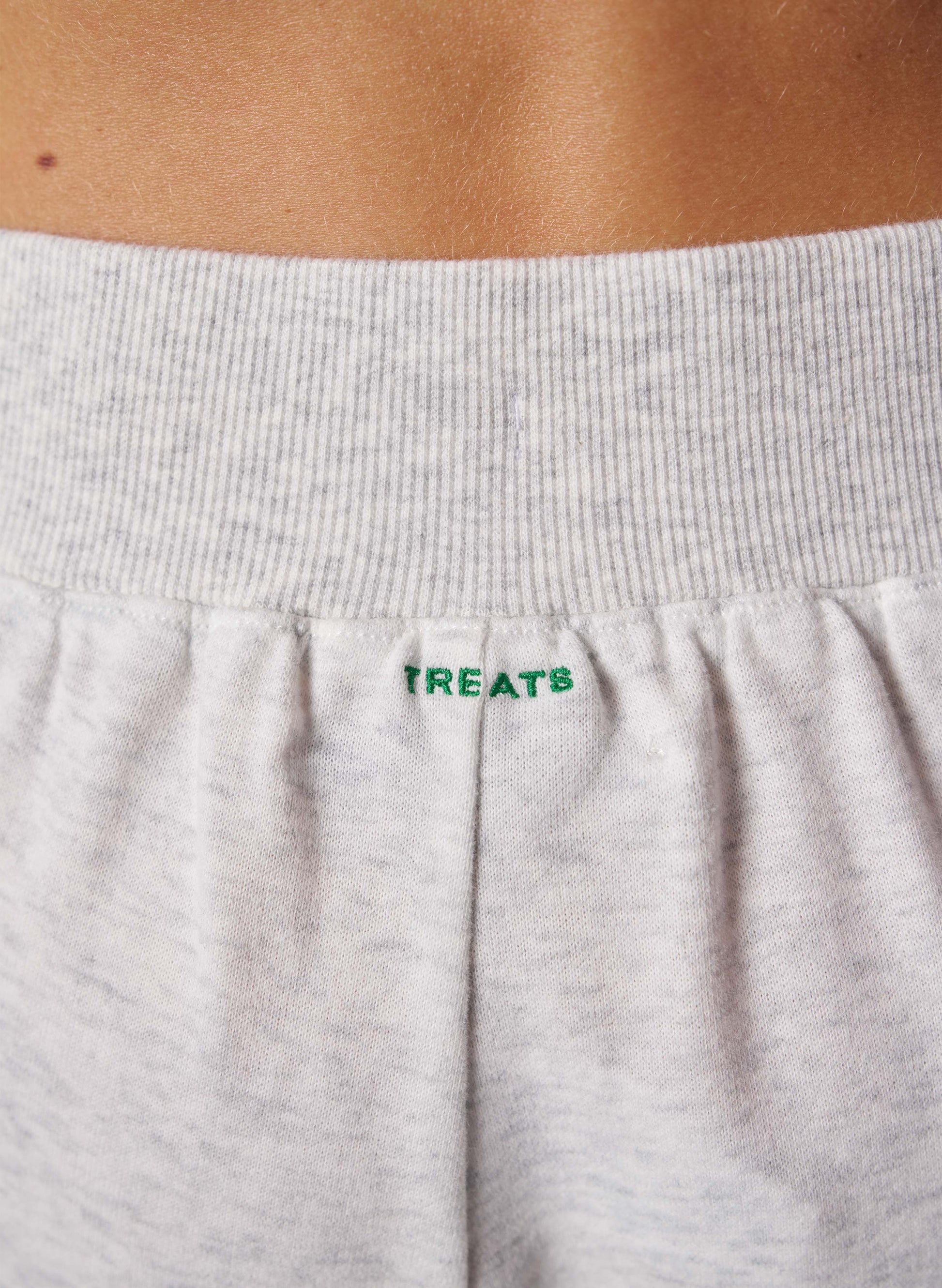 Gray sweatpants with 'TREATS' branding on the waistband.