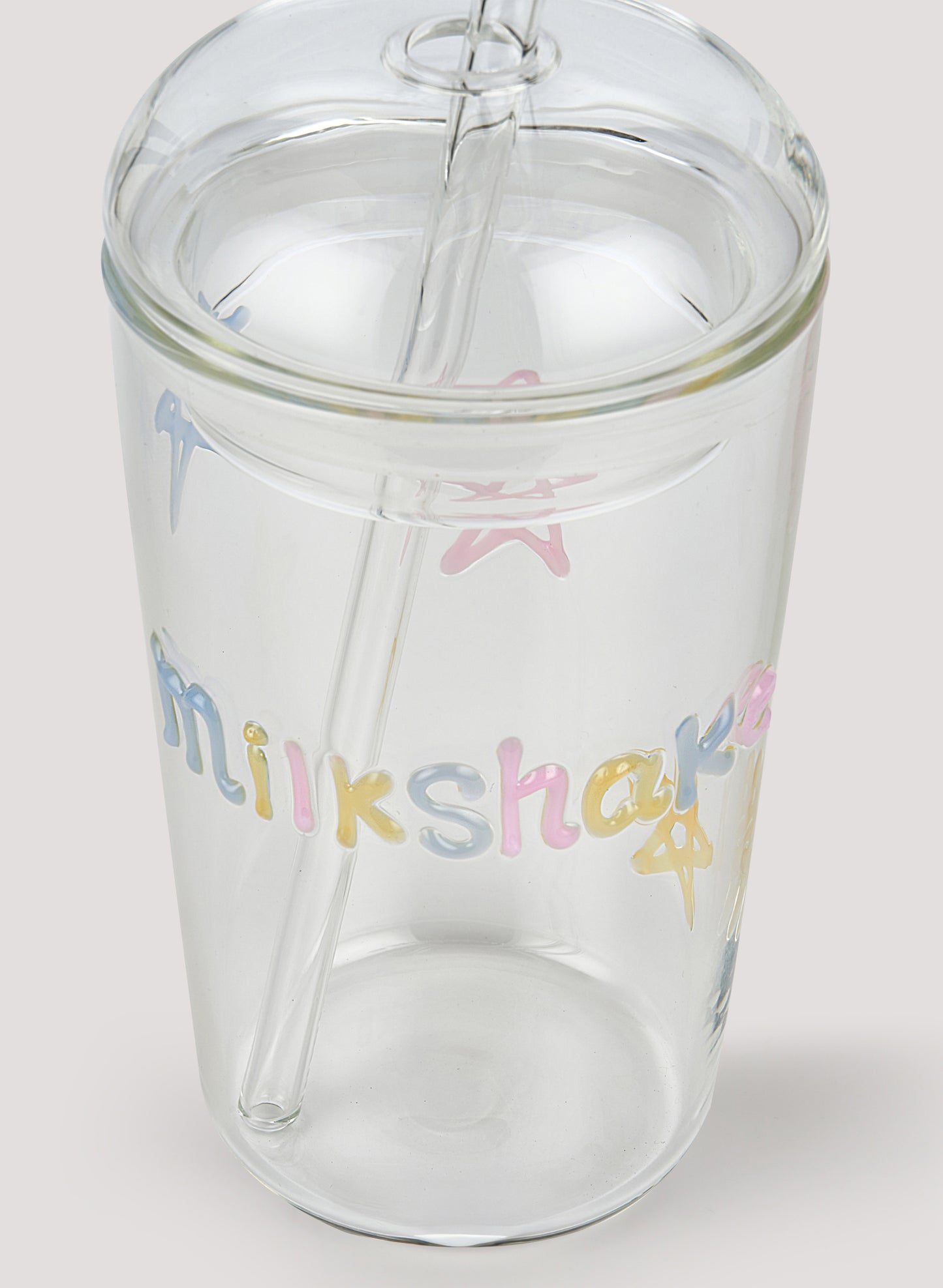 Clear tumbler with colorful 'milkshake' text on a white background