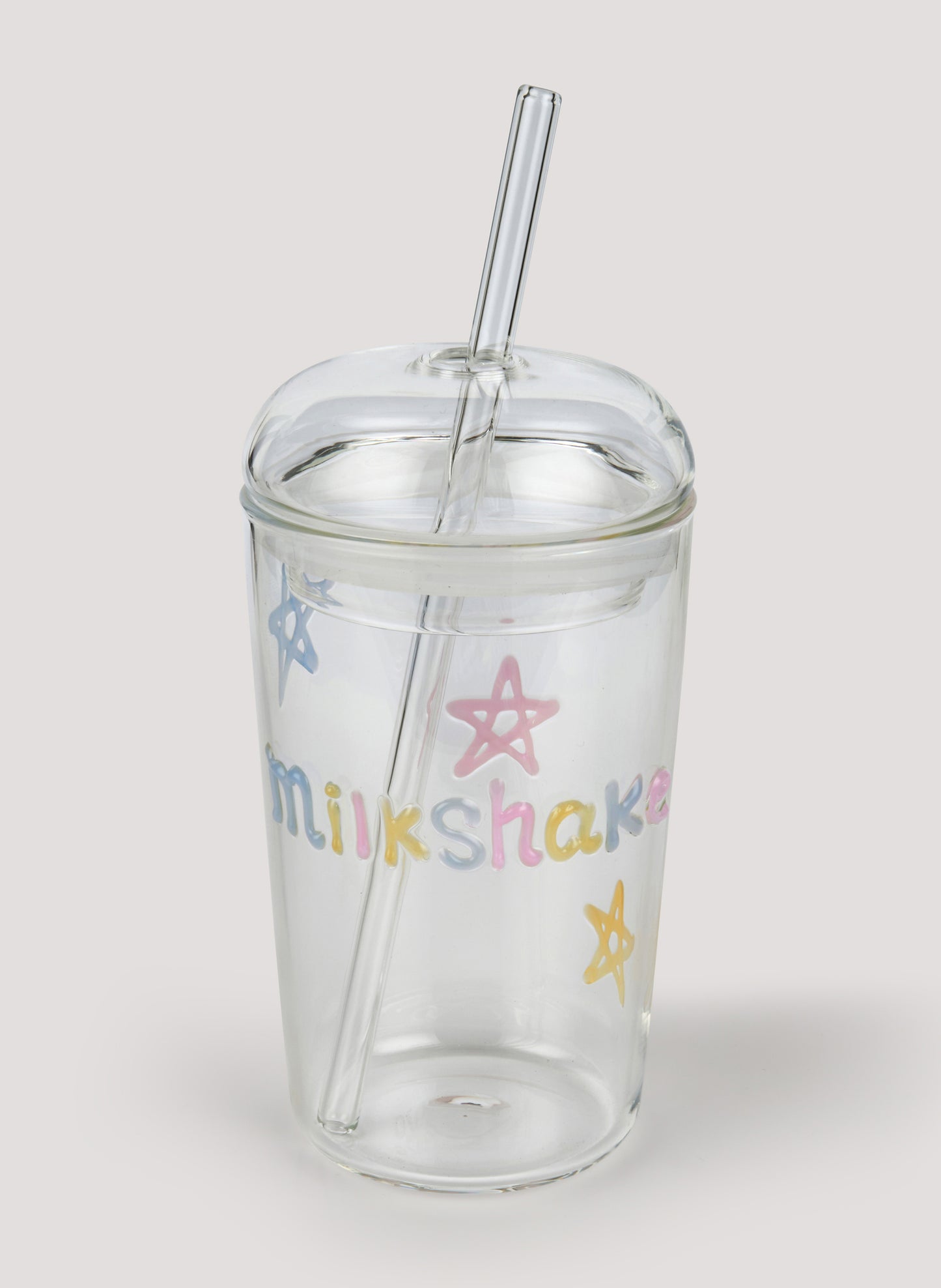 Clear tumbler with colorful 'milkshake' text and star designs on a white background
