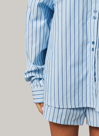 Blue and white striped shirt and shorts set on a neutral background