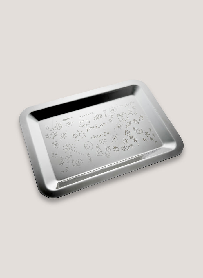 Metal tray with decorative patterns on a light gray background