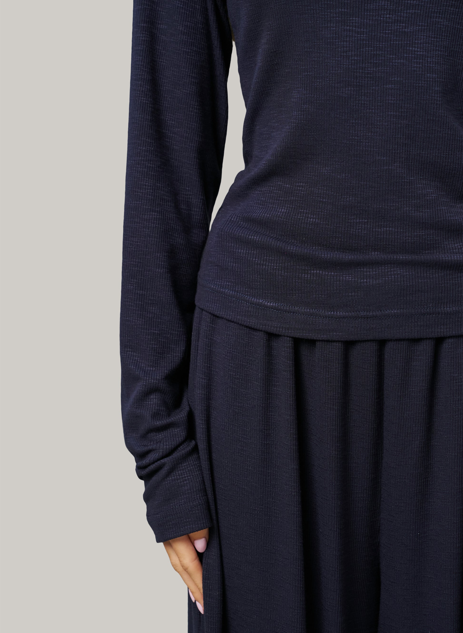 Navy long-sleeve top and skirt set on a plain background