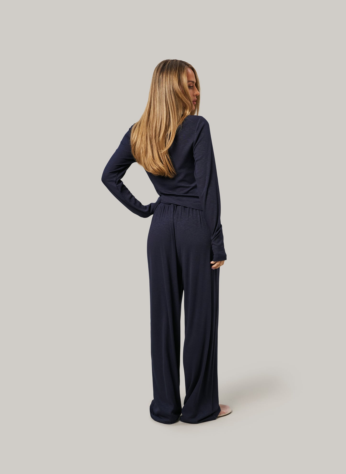 Woman wearing a navy blue set on a plain background