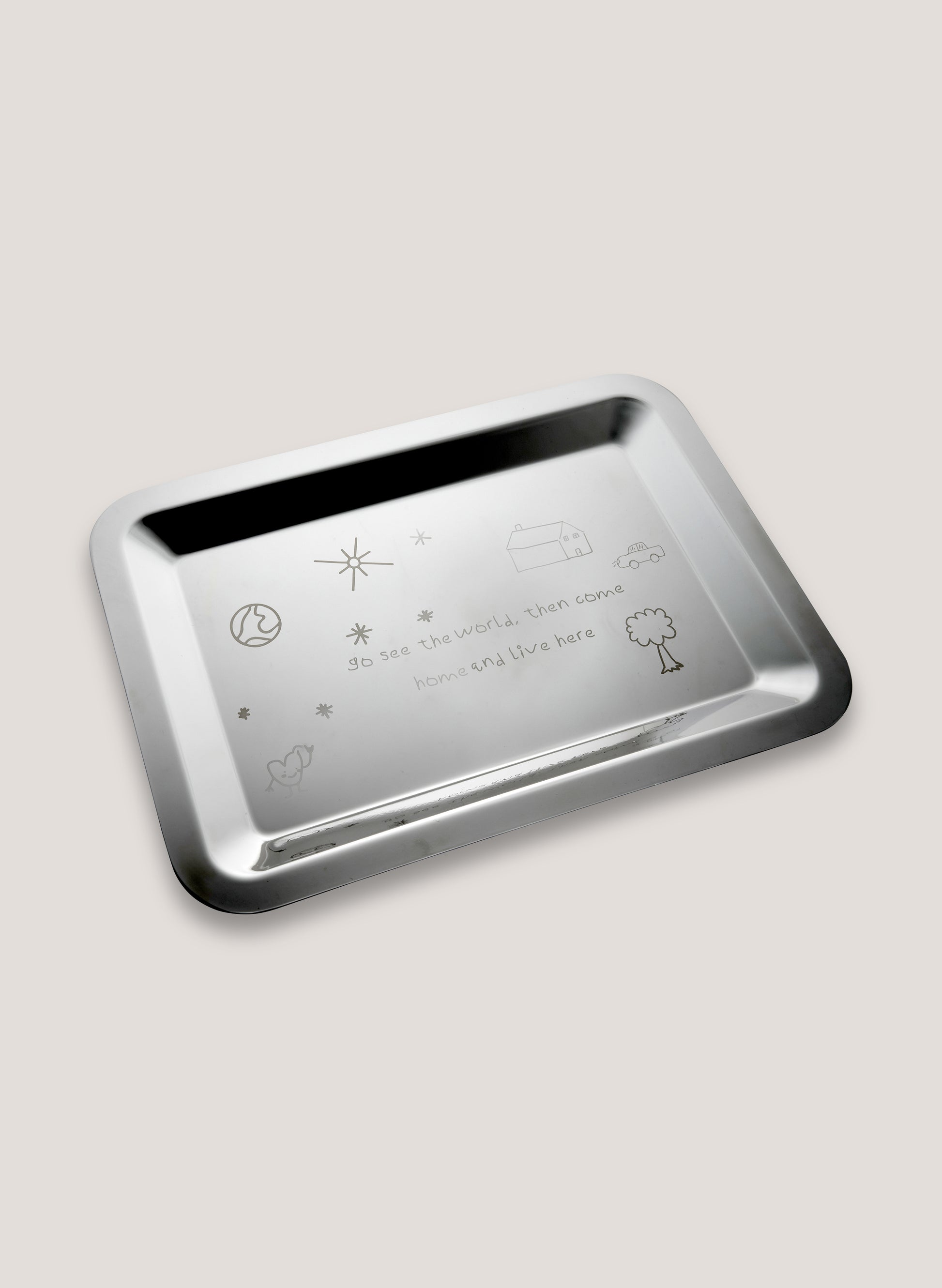 Silver tray with engraved symbols and text on a light gray background