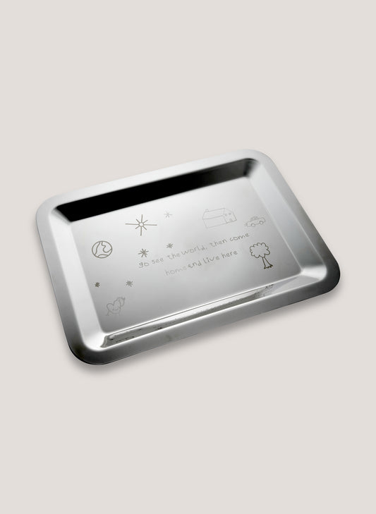 Silver tray with engraved symbols and text on a light gray background