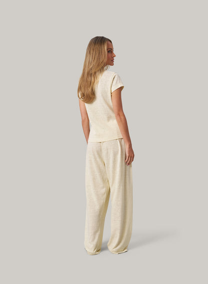 Woman wearing a butter colour outfit on a plain background