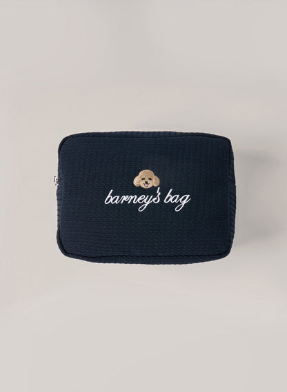 Navy waffle-textured pouch with zipper closure, featuring a dog face embroidery and ‘barney’s bag’ text on the front