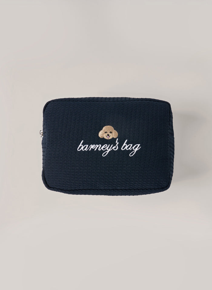 Navy waffle-textured pouch with zipper closure, featuring a dog face embroidery and ‘barney’s bag’ text on the front
