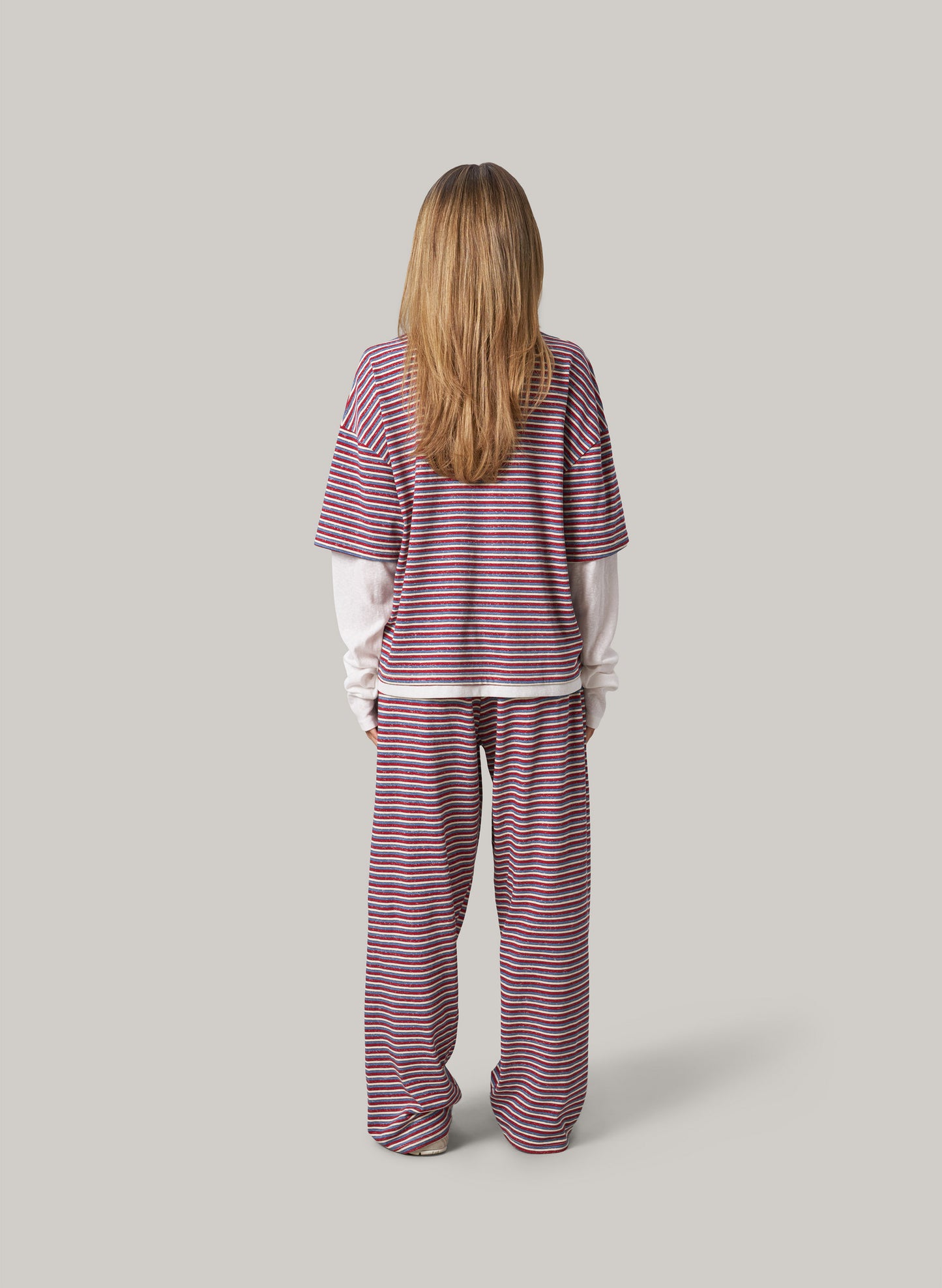 Person wearing a striped set on a plain background
