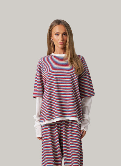 Woman wearing a striped outfit with a plain background