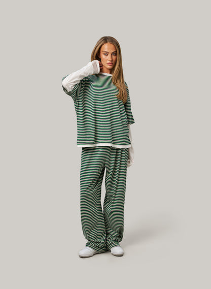 Woman wearing a green and white striped outfit on a gray background